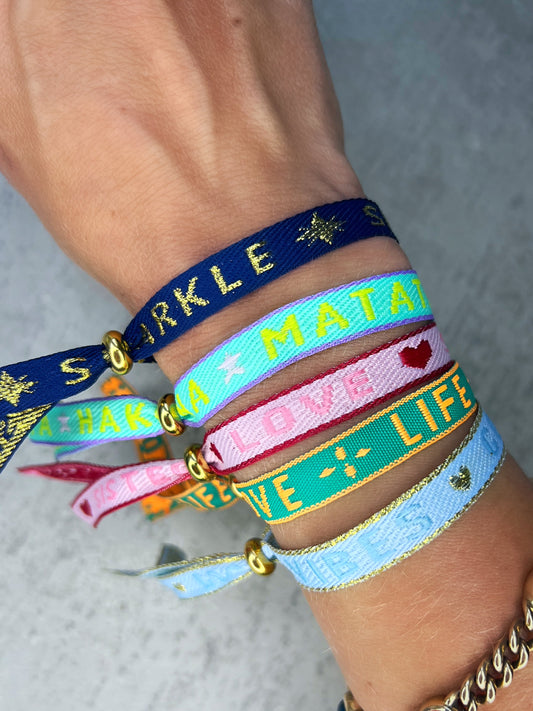 Dieses-Armband besteht aus sehr haltbarem Polyester und hat die Aufschrift "GOOD VIBES". Die goldfarbene Stopper-Perle ist aus rostfreiem Stahl.