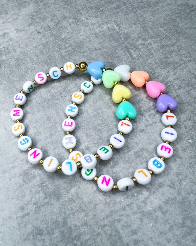 Dieses Armband ist handgearbeitet aus:
kunterbunten Buchstaben-Perlen aus Acryl,
einer Herz-Perle aus Acryl,
einem goldfarbenen Herzen &
Zwischen-Perlen aus Edelstahl und
einer goldfarbenen Edelstahl-Verschlussperle