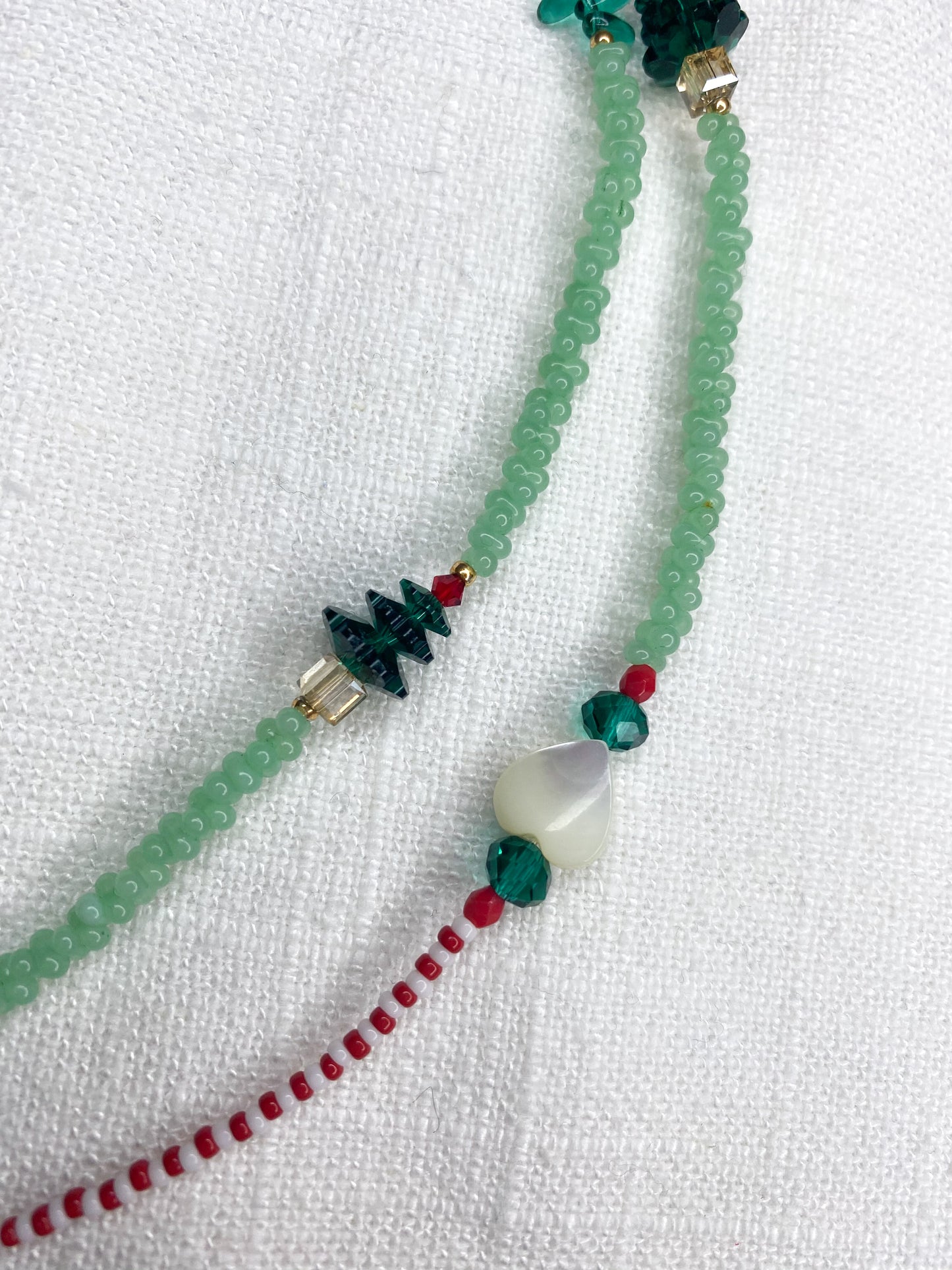 Handgefertigte Brillenkette aus individuell ausgesuchten und hochwertigen Perlen – damit Du nie wieder Deine Brille liegen lässt!
Gefertigt aus:
Glasperlen in Grün, rot und weiß, 2 Perlmutt-Herzen und 2 Swarovski-Tannenbäumen.