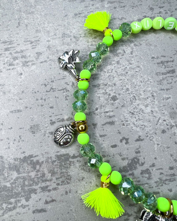 Von Hand gefertigter Schmuck für Dein Haustier. Die Wiesn-Kette besteht aus grüne glitzernden, facettierten Glasperlen, grünen Polymerperlen, grünen Acryl-Buchstabenperlen, neon-gelben Quasten, silberfarbenen Wiesn-Anhängern, sowie einer goldfarbenen Edelstahlkugel.