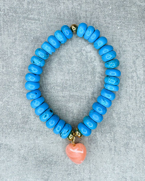 Dieses Armband ist handgearbeitet aus:
türkisen Howlith-Perlen, Zwischenperlen aus goldfarbenem Edelstahl, einem pfirsich-farbenem Herzanhänger aus Acryl und einer goldfarbenen Edelstahlkugel.
"Der Howlith steht für Intuition. Er fördert die Toleranz, kann dir bei der Selbstreflektion helfen und wirkt ausgleichend."