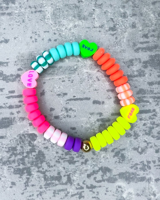 Kinder-Armband aus wunderschönen bunten und ausgesuchten Perlen! Dieses Armband ist handgearbeitet aus: kunterbunten und pastellfarbenen, matten Polymer-Scheibenperlen, Polymer-Herzen und einer goldfarbenen Edelstahlkugel.