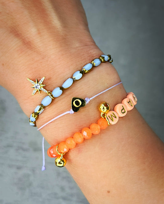 Handgemachtes Armband aus wunderschönen und ausgesuchten Perlen! Dieses Armband ist handgearbeitet aus: pfirsich-farbenen, facettierten Glasperlen, goldfarbenen Metall-Glöckchen, pfirsich-farbenen Acryl-Buchstabenperlen und einer goldfarbenen Edelstahl-Verschlusskugel.