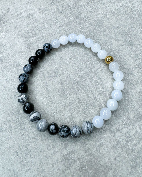 Heilstein-Armband aus wunderschönen, feinen und ausgesuchten Perlen!
Dieses Armband ist handgearbeitet aus:
Schwarz-grauen Schneeflocken-Obsidian-Perlen, soft, hellblauen Jade-Perlen und
einer goldfarbenen Edelstahlkugel.
"Schneeflocken Obsidian hilft dabei, hilflose Gedanken und Stresssituationen zu erkennen und loszulassen. Dieser Stein kann helfen, die Konzentration zu steigern. Schneeflockenobsidian ist ein angenehmer Stein, um traumatische Erlebnisse zu verarbeiten.”
"Der Jade gilt als der Stein der&
