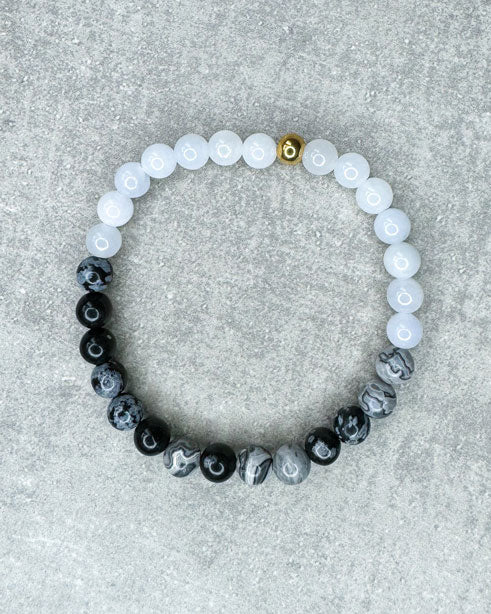 Heilstein-Armband aus wunderschönen, feinen und ausgesuchten Perlen!
Dieses Armband ist handgearbeitet aus:
Schwarz-grauen Schneeflocken-Obsidian-Perlen, soft, hellblauen Jade-Perlen und
einer goldfarbenen Edelstahlkugel.
"Schneeflocken Obsidian hilft dabei, hilflose Gedanken und Stresssituationen zu erkennen und loszulassen. Dieser Stein kann helfen, die Konzentration zu steigern. Schneeflockenobsidian ist ein angenehmer Stein, um traumatische Erlebnisse zu verarbeiten.”
"Der Jade gilt als der Stein der&