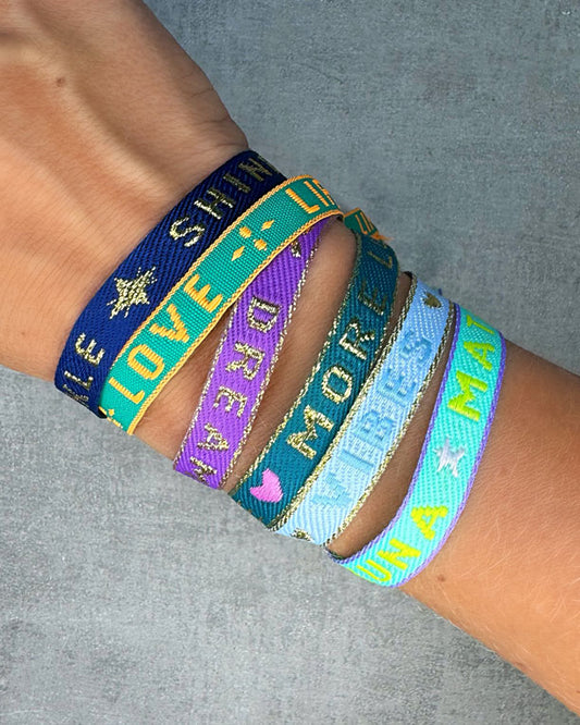 Dieses-Armband besteht aus sehr haltbarem Polyester und hat die Aufschrift "DREAMER". Die goldfarbene Stopper-Perle ist aus rostfreiem Stahl.