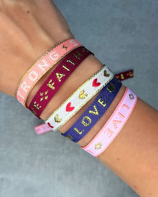 Dieses-Armband besteht aus sehr haltbarem Polyester und hat die Aufschrift "LIVE LAUGH LOVE". Die goldfarbene Stopper-Perle ist aus rostfreiem Stahl.