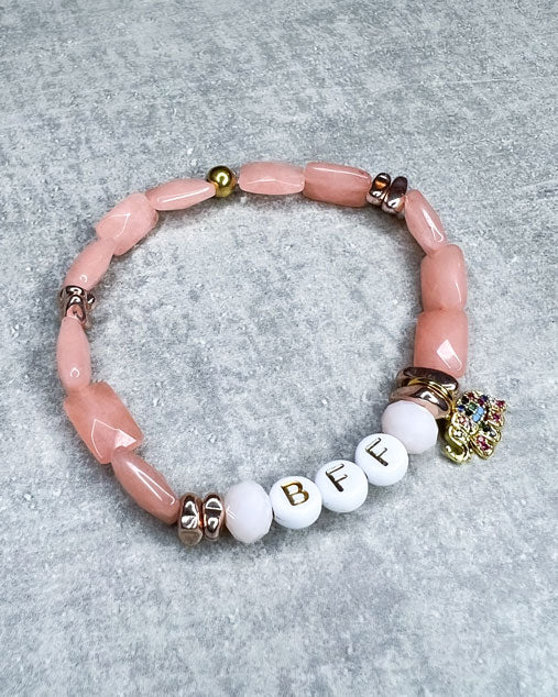 Buchstaben-Armband mit wunderschönen, feinen und ausgesuchten Perlen. Dieses Armband ist handgearbeitet aus: wunderschönen facettierten, lachs/rosé farbenen Jade-Perlen, weißen Acryl-Buchstabenperlen, roségold farbenen Hämatit-Perlen, einem vergoldeten Elefanten-Anhänger mit bunten Zirkonia-Glitzersteinen, und einer goldfarbenen Edelstahlkugel.