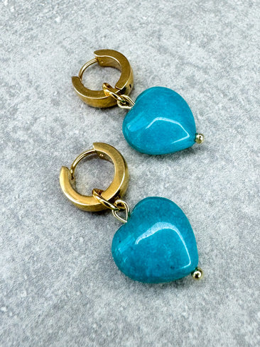 Diese Ohrringe sind gefertigt aus einer kleinen Creole aus rostfreiem Stahl in 11mm Durchmesser und einem türkis gefärbten Jade-Herz als Anhänger.