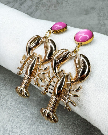 Dieser Ohrring ist gefertigt aus einem Cabochon-Ohrsstecker aus rostfreiem Stahl mit einem glänzenden, rosanen Cabochon-Stein und einem goldfarbenen Lobster-Anhänger.