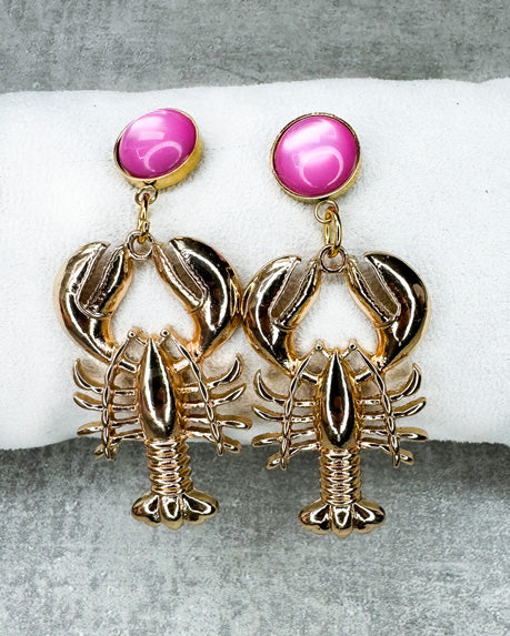 Dieser Ohrring ist gefertigt aus einem Cabochon-Ohrsstecker aus rostfreiem Stahl mit einem glänzenden, rosanen Cabochon-Stein und einem goldfarbenen Lobster-Anhänger.