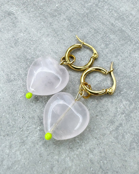 Diese Ohrringe sind gefertigt aus einer kleinen Creole aus rostfreiem Stahl in 12mm Durchmesser und einem sehr soft rosafarbenem Rosenquarz-Herz als Anhänger.
