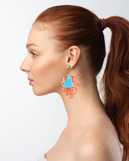 Dieser Ohrring ist gemacht mit: einem Ohrstecker aus rostfreiem Stahl in "Lilien-Optik", einem Ornament-Anhänger in der Farbe "Coral" und einer großen türkisen Quaste.