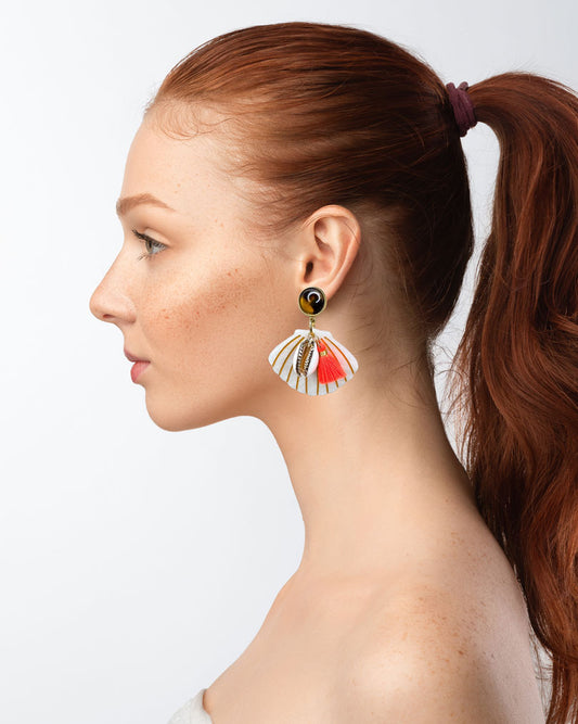Dieser Ohrring ist gefertigt aus einem Polaris Steel Ohrstecker, einem Cabochon-Stein in Schildpatt-Optik, einem weiß glitzernden Muschel-Anhänger aus Acryl, einer gold verzierten Muschel als Anhänger und einer neon orangenen Quaste.