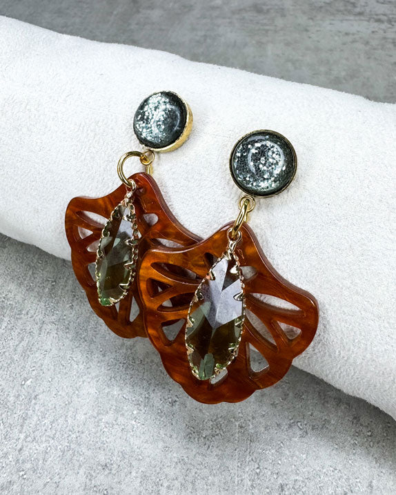 Dieser Ohrring ist gemacht mit:
einem goldfarbenen "Polaris Steel" Ohrstecker mit einem grün glitzernden Cabochon Stein, einem Ornament-Anhänger in der Farbe "Rosewood" und einem grün facettierten und gold gefassten Anhänger.