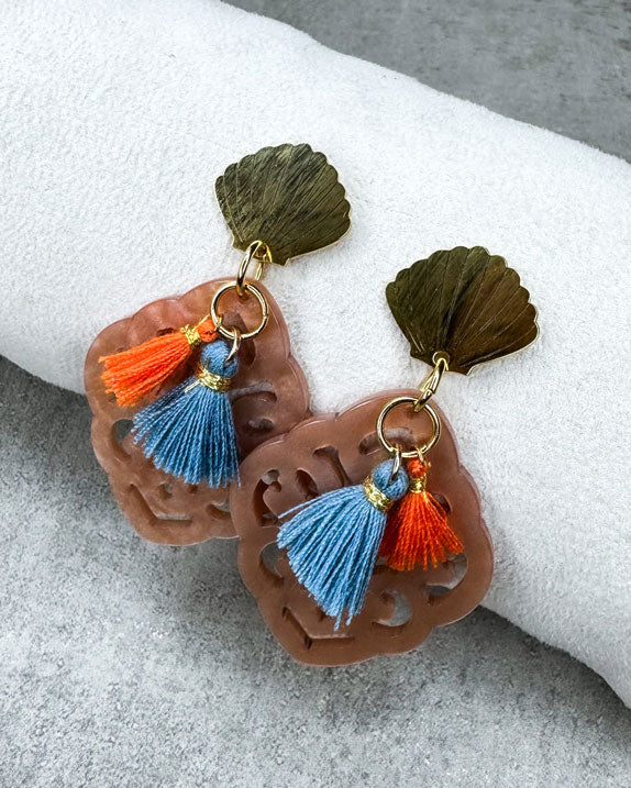 Dieser Ohrring ist gemacht mit:
einem goldfarbenen Muschel-Ohrstecker aus rostfreiem Stahl, einem Ornament-Anhänger in der Farbe "Nude" und 2 Quasten in Burnt Orange und Denim Blue.