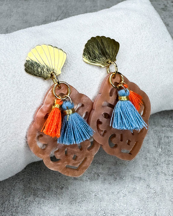 Dieser Ohrring ist gemacht mit:
einem goldfarbenen Muschel-Ohrstecker aus rostfreiem Stahl, einem Ornament-Anhänger in der Farbe "Nude" und 2 Quasten in Burnt Orange und Denim Blue.