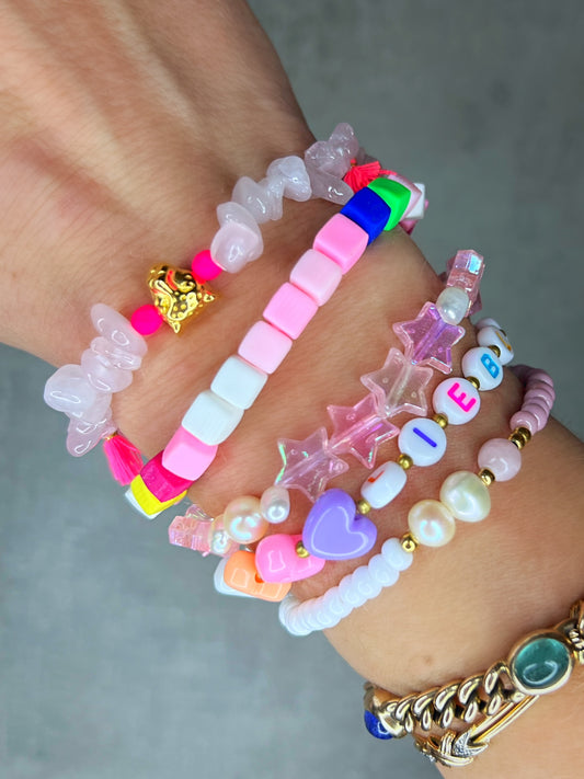 Dieses Armband ist handgearbeitet aus: 

kunterbunten Buchstaben-Perlen aus Acryl, 
einer Herz-Perle aus Acryl, 
einem goldfarbenen Herzen & 
Zwischen-Perlen aus Edelstahl und
einer goldfarbenen Edelstahl-Verschlussperle