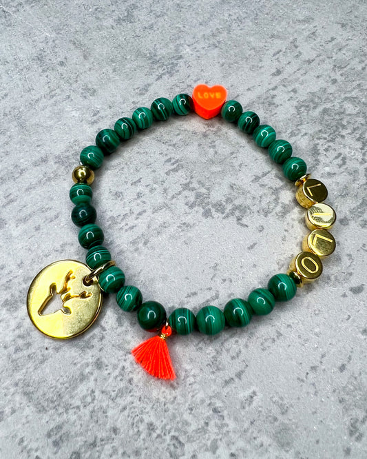 Das Armband ist aus grünen Malachit-Edelstein-Perlen, goldfarbenen Metall-Buchstaben-Perlen, einem orangefarbenem Polymer-Herzen, einer Neon-orangenen Quaste und einer goldfarbenen Edelstahlkugel.  Das Halsband ist aus grün gefärbten, facettierten Jade-Edelstein-Perlen, orangefarbenen Buchstaben-Perlen, einem orangefarbenem Polymer-Herzen, einer Neon-orangenen Quaste und einer goldfarbenen Edelstahlkugel.