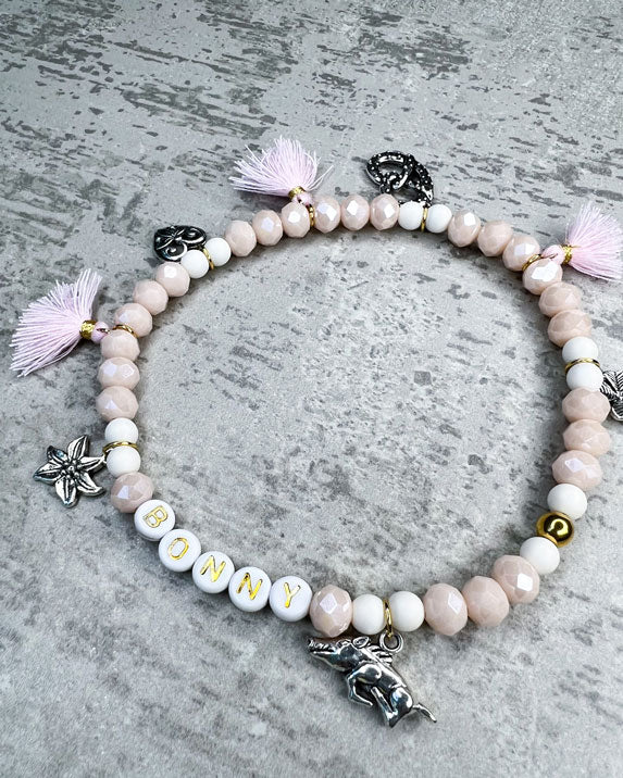 Wiesn-Halsband, Oktoberfest-Halsband, Von Hand gefertigter Schmuck für Dein Haustier.  Die Kette besteht aus beige glitzernden, facettierten Glasperlen, weißen Acrylperlen, weißen Acryl-Buchstabenperlen, osafarbenen Quasten, silberfarbenen Wiesn-Anhängern, sowie einer goldfarbenen Edelstahlkugel. 