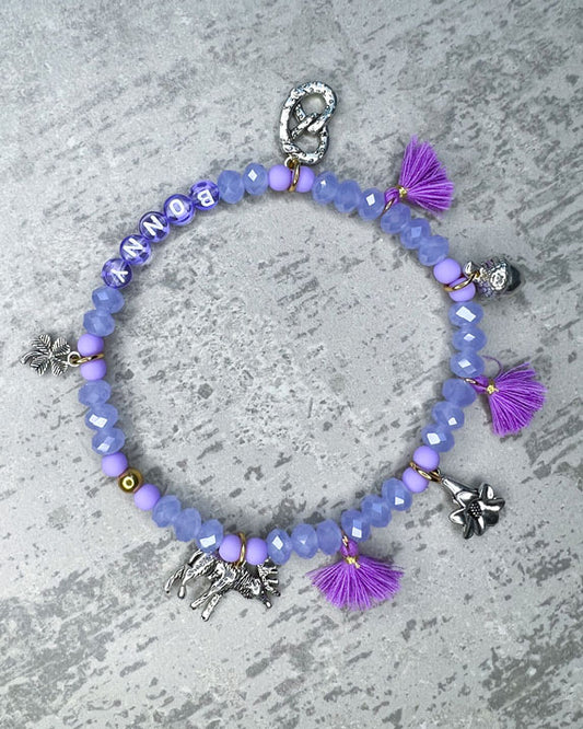 Von Hand gefertigter Schmuck für Dein Haustier.  Die Wiesn-Kette besteht aus lila glitzernden, facettierten Glasperlen, lilafarbenen Polymer, lila Acryl-Buchstabenperlen, lilafarbenen Quasten, silberfarbenen Wiesn-Anhängern, sowie einer goldfarbenen Edelstahlkugel. 