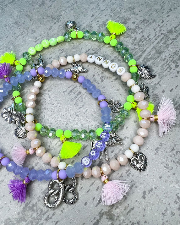 Von Hand gefertigter Schmuck für Dein Haustier.  Die Wiesn-Kette besteht aus lila glitzernden, facettierten Glasperlen, lilafarbenen Polymer, lila Acryl-Buchstabenperlen, lilafarbenen Quasten, silberfarbenen Wiesn-Anhängern, sowie einer goldfarbenen Edelstahlkugel. 