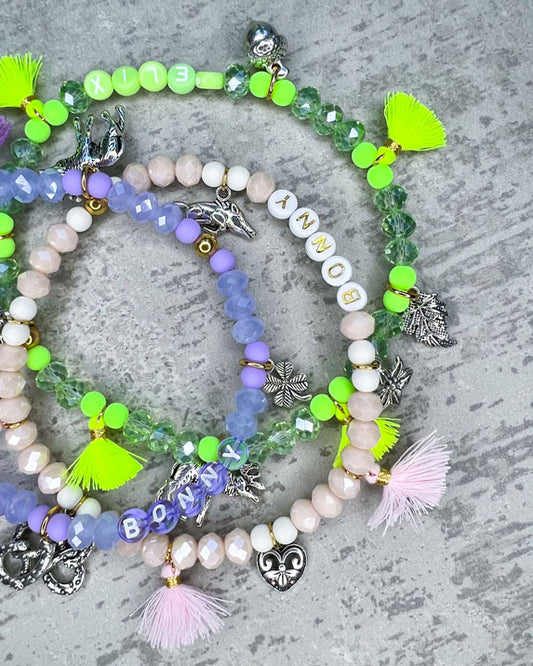 Wiesn-Halsband, Oktoberfest-Halsband, Von Hand gefertigter Schmuck für Dein Haustier.  Die Kette besteht aus beige glitzernden, facettierten Glasperlen, weißen Acrylperlen, weißen Acryl-Buchstabenperlen, osafarbenen Quasten, silberfarbenen Wiesn-Anhängern, sowie einer goldfarbenen Edelstahlkugel. 