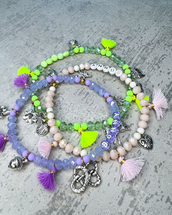 Wiesn-Halsband, Oktoberfest-Halsband, Von Hand gefertigter Schmuck für Dein Haustier.  Die Kette besteht aus beige glitzernden, facettierten Glasperlen, weißen Acrylperlen, weißen Acryl-Buchstabenperlen, osafarbenen Quasten, silberfarbenen Wiesn-Anhängern, sowie einer goldfarbenen Edelstahlkugel. 