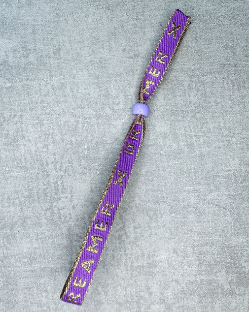 Dieses-Armband besteht aus sehr haltbarem Polyester und hat die Aufschrift "DREAMER". Die goldfarbene Stopper-Perle ist aus rostfreiem Stahl.