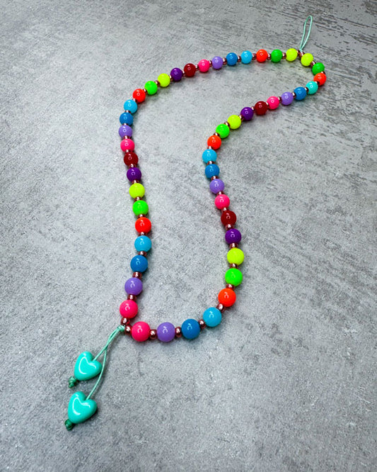 Eine von uns handgefertigte Handykette aus ausgesuchten und Perlen – damit Du&nbsp;nie wieder&nbsp;Dein Handy liegen lässt!

Gefertigt aus:
kunterbunten, neonfarbenen Acryl-Perlen (sehr leicht),
kleinen bronzefarbenen Acrylperlen in den Zwischenräumen
und einer langen Quaste in Peach.

Diese kurze Handykette ist ca. 20 cm lang – wenn Du aber eine andere Länge benötigst, schreib uns gerne in den Anmerkungen.

Die Kette ist auf langlebiges Shamballa-Band gezogen.