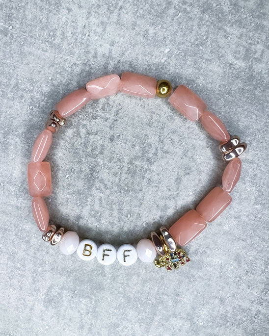 Buchstaben-Armband mit wunderschönen, feinen und ausgesuchten Perlen.  Dieses Armband ist handgearbeitet aus: wunderschönen facettierten, lachs/rosé farbenen Jade-Perlen, weißen Acryl-Buchstabenperlen, roségold farbenen Hämatit-Perlen, einem vergoldeten Elefanten-Anhänger mit bunten Zirkonia-Glitzersteinen, und einer goldfarbenen Edelstahlkugel.
