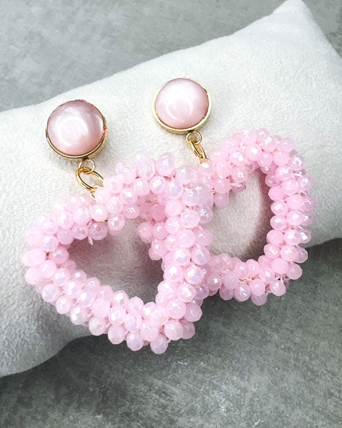Dieser Ohrring ist gefertigt aus einem Cabochon-Ohrsstecker aus rostfreiem Stahl mit einem glänzenden, rosanen Cabochon-Stein und einem glitzernden Facetten-Herz-Anhänger in der Farbe "Baby Rose".