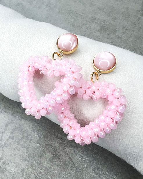 Dieser Ohrring ist gefertigt aus einem Cabochon-Ohrsstecker aus rostfreiem Stahl mit einem glänzenden, rosanen Cabochon-Stein und einem glitzernden Facetten-Herz-Anhänger in der Farbe "Baby Rose".