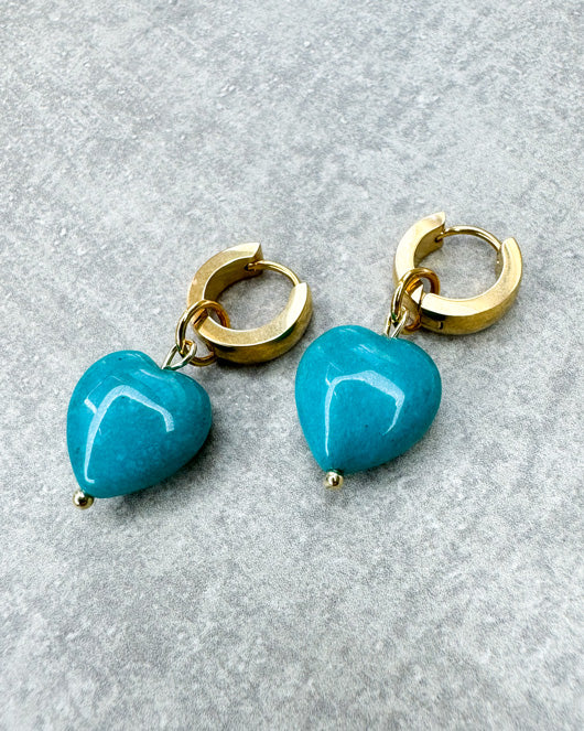 Diese Ohrringe sind gefertigt aus einer kleinen Creole aus rostfreiem Stahl in 11mm Durchmesser und einem türkis gefärbten Jade-Herz als Anhänger.