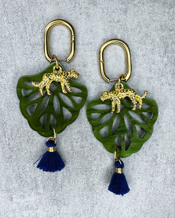 Dieser Ohrring ist gefertigt aus einer Creole aus rostfreiem Stahl mit weißen Zirkonia-Glitzersteinen vorne, einem Ornament-Anhänger in Green, einem goldfarbenen Panther als Anhänger und einer Quaste in Dunkelblau.