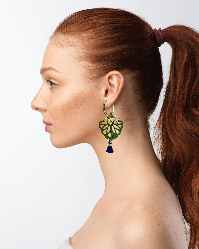 Dieser Ohrring ist gefertigt aus einer Creole aus rostfreiem Stahl mit weißen Zirkonia-Glitzersteinen vorne, einem Ornament-Anhänger in Green, einem goldfarbenen Panther als Anhänger und einer Quaste in Dunkelblau.