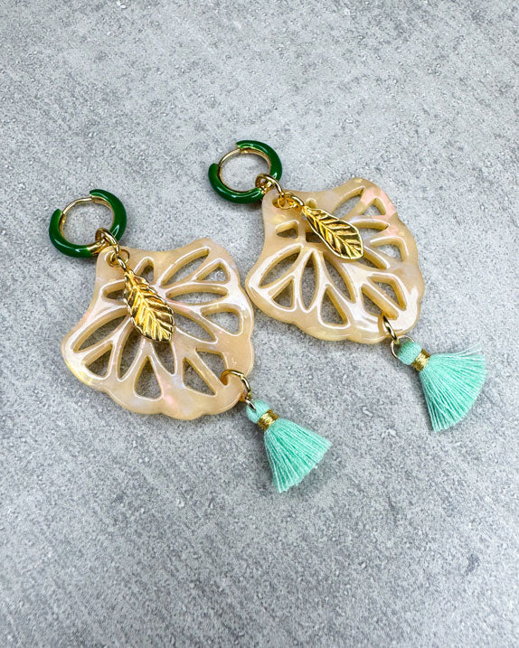 Dieser Ohrring ist gemacht mit:
einer gold- und grünen Creole, einem Ornament-Anhänger in der Farbe "Beige Glitter", einem goldfarbenen Feder-Anhänger und einer hellgrünen Quaste.