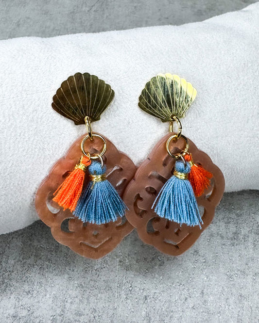 Dieser Ohrring ist gemacht mit:
einem goldfarbenen Muschel-Ohrstecker aus rostfreiem Stahl, einem Ornament-Anhänger in der Farbe "Nude" und 2 Quasten in Burnt Orange und Denim Blue.