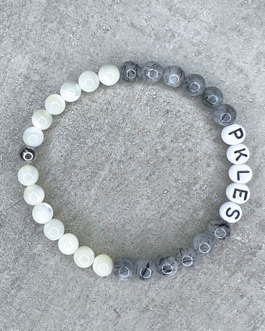Diese Armband ist handgemacht aus wunderschönen, feinen und ausgesuchten Perlen!  Dieses Armband ist handgearbeitet aus: runden, grauen Turmalinquarz-Edelsteinen, weißen Perlmutt-Perlen, weißen Acryl-Buchstaben-Perlen und einer silbernen Edelstahlkugel.