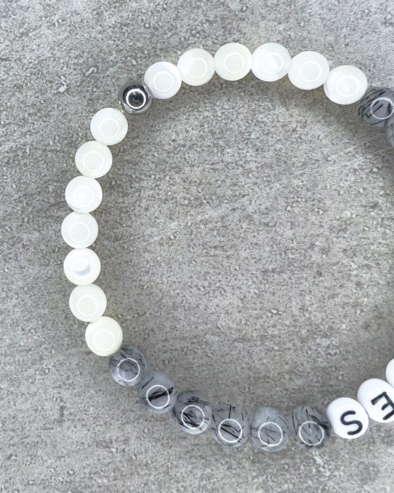 Diese Armband ist handgemacht aus wunderschönen, feinen und ausgesuchten Perlen!  Dieses Armband ist handgearbeitet aus: runden, grauen Turmalinquarz-Edelsteinen, weißen Perlmutt-Perlen, weißen Acryl-Buchstaben-Perlen und einer silbernen Edelstahlkugel.