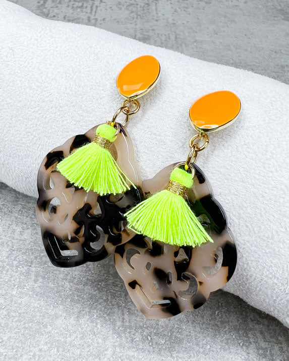 Dieser Ohrring ist handgefertigt für Euch!  Er besteht aus: einem länglichen Ohrstecker in Neon-Orange mit einem schildpatt-farbenen Ornament-Anhänger und einer neongelben Quaste.