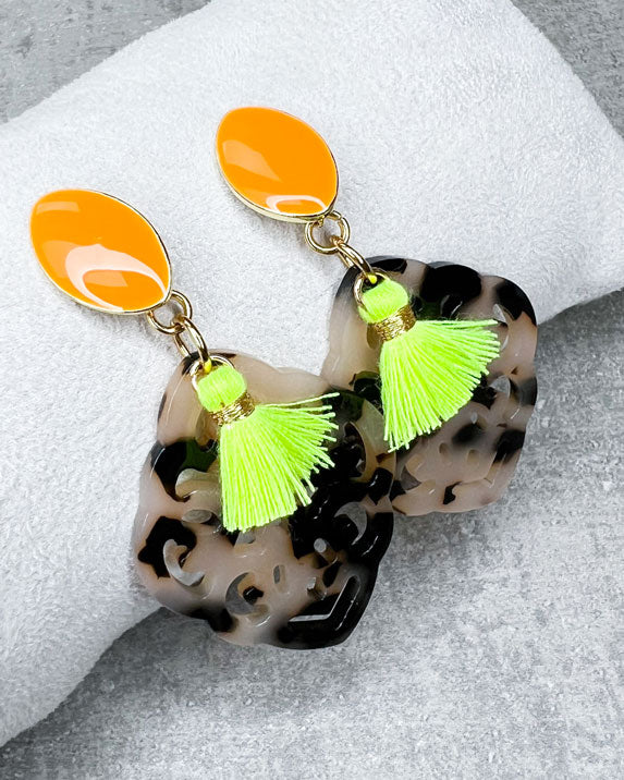 Dieser Ohrring ist handgefertigt für Euch!  Er besteht aus: einem länglichen Ohrstecker in Neon-Orange mit einem schildpatt-farbenen Ornament-Anhänger und einer neongelben Quaste.