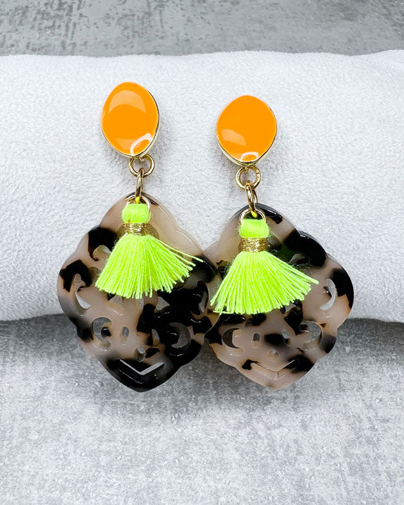 Dieser Ohrring ist handgefertigt für Euch!  Er besteht aus: einem länglichen Ohrstecker in Neon-Orange mit einem schildpatt-farbenen Ornament-Anhänger und einer neongelben Quaste.