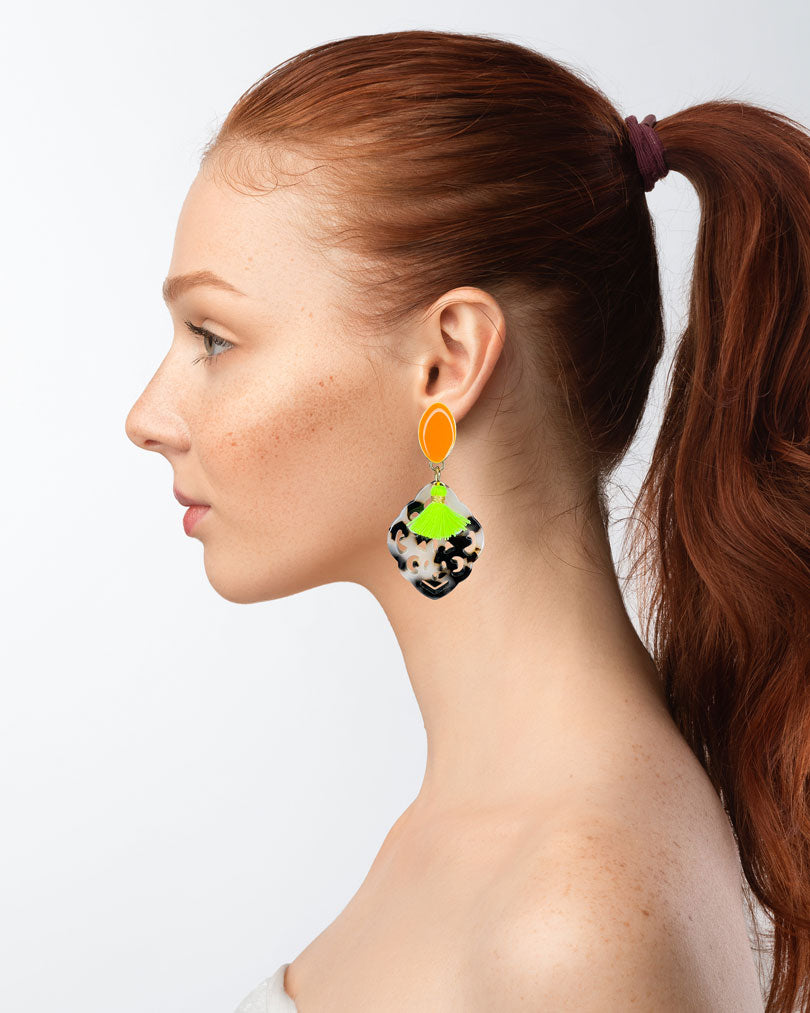 Dieser Ohrring ist handgefertigt für Euch!  Er besteht aus: einem länglichen Ohrstecker in Neon-Orange mit einem schildpatt-farbenen Ornament-Anhänger und einer neongelben Quaste.